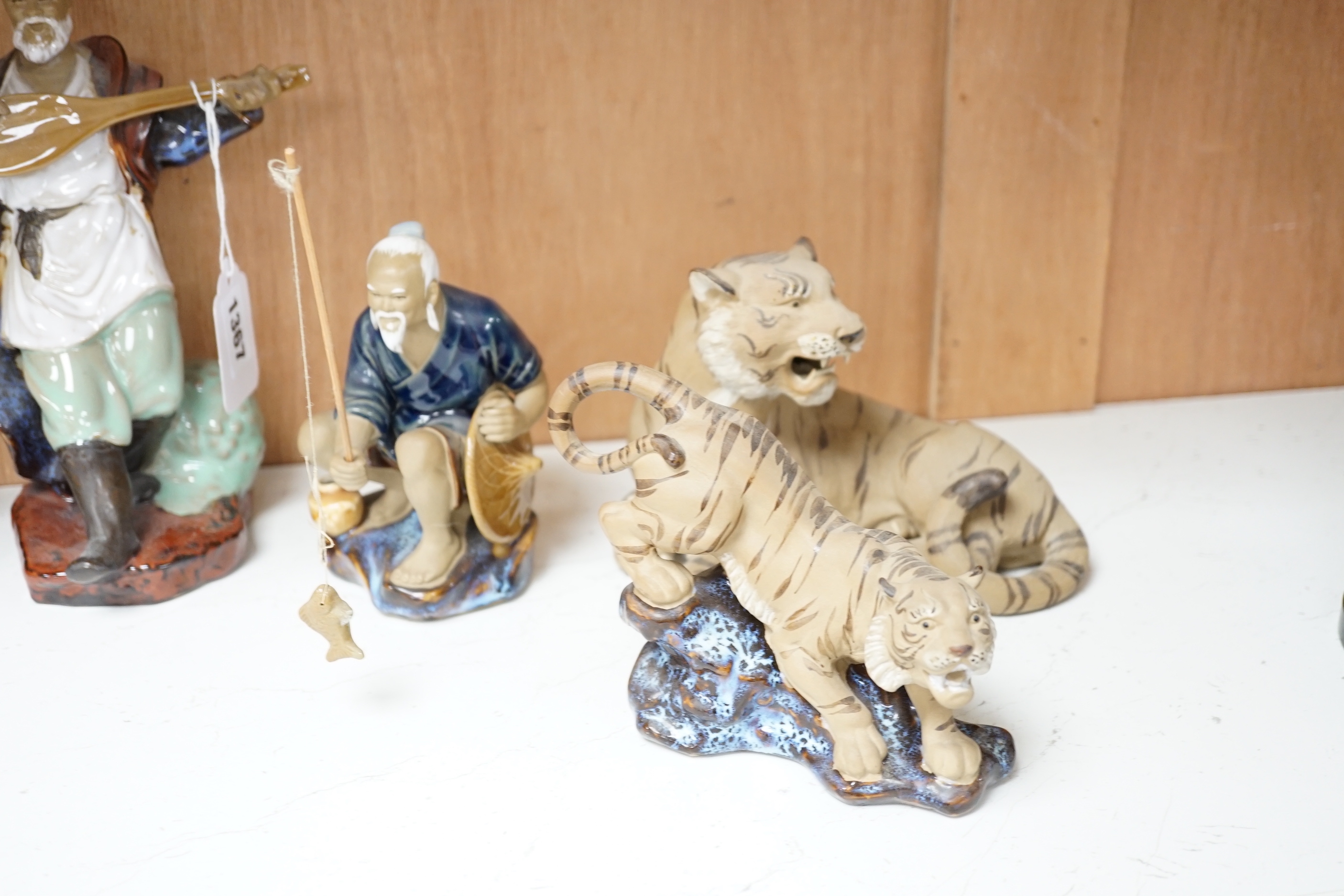 Thirteen Shiwan pottery figure groups of tigers and figures, the largest 25cm high